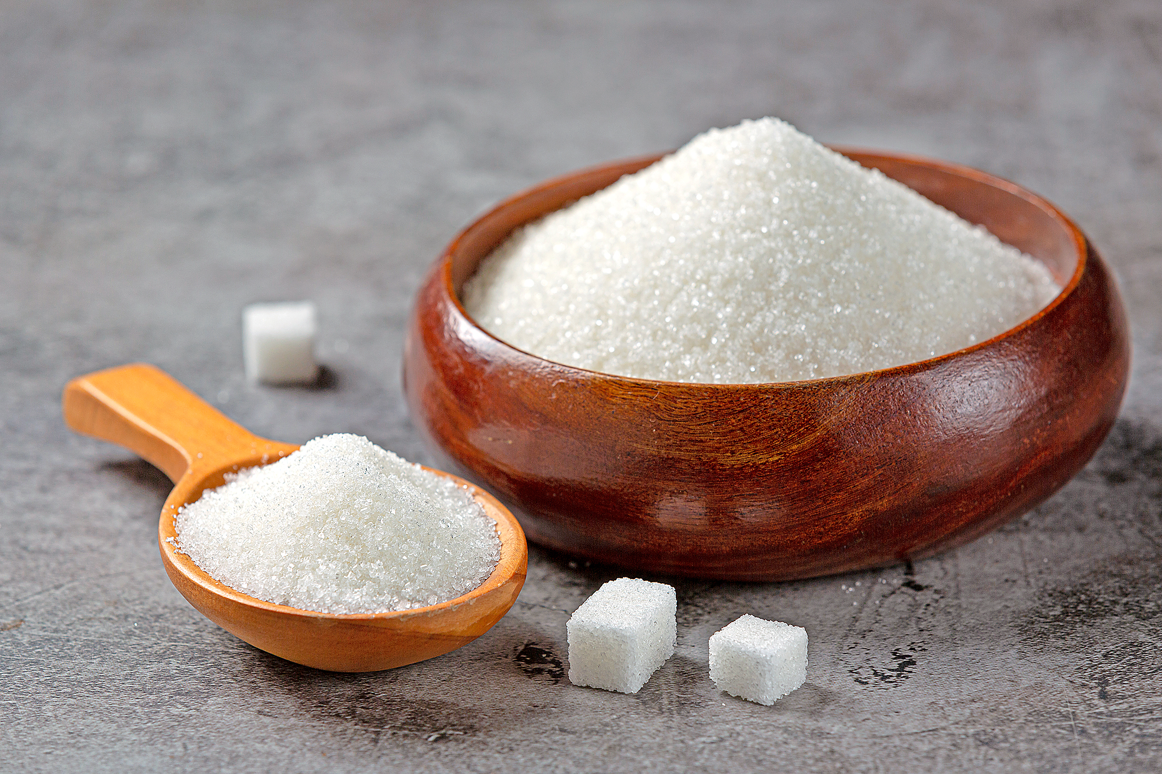 World diabetes day; sugar in wooden bowl on dark background